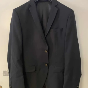 Kostym Jack&Jones - Säljer min kostym då jag nyligen köpt en ny. Den är i mycket fint skick och endast använd ett fåtal gånger.  Kavajen är storlek 46 och byxorna stolek 48. 