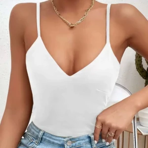 Vit body med smala axelband - Snygg vit body med smala, justerbara axelband och djup v-ringning framtill. Använd endast en gång! Skriv för fler bilder eller detaljer💕☺️