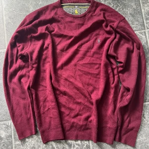 Vinröd stickad tröja Polo Ralph Lauren - Snygg vinröd stickad tröja från Polo Ralph Lauren med klassisk rund hals och broderad logga på bröstet. Tröjan har lång ärm och är perfekt för dig som gillar stilrena plagg med premiumkänsla. Passar dig som vill ha en enkel men ändå lyxig look. Priset kan diskuteras vid snabb affär 