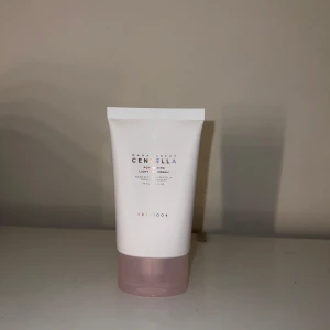 SKIN1004 Centella Poremizing Primer - SKIN1004 Centella Poremizing Light Gel Cream är en primer i en vit tub med rosa botten, innehållande 75 ml. Formulan är lätt gelkräm och innehåller ren centella från Madagaskar, perfekt för att jämna ut huden innan smink. Endast testat 