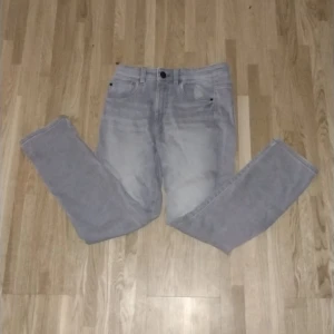 Grå jeansbyxor från Kappahl, stl 140 - Snygga grå jeansbyxor från Kappahl i storlek 140. Byxorna har klassisk femficksdesign, raka ben och normal passform. Perfekta för dig som gillar en stilren och enkel look. Tillverkade i mjuk bomullsblandning för extra komfort.