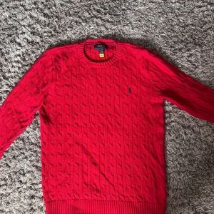 Röd stickad tröja från Polo Ralph Lauren🤩 - Säljer en snygg röd stickad tröja från Polo Ralph Lauren med klassisk kabelstickning och rund hals, i storlek S🙌✅🤝