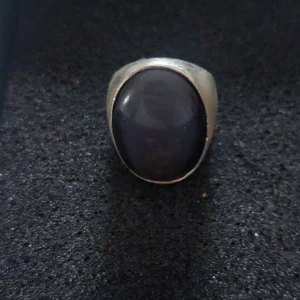 Silverring med stor blå sten - Snygg och stilren silverring med en stor, oval blå sten i mitten. Ringen har en bred design som gör den till ett iögonfallande smycke.