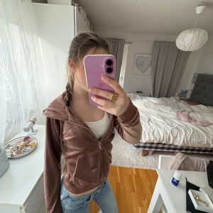 Brun hoodie från Juicy Couture - Säljer en brun hoodie från Juicy Couture i storlek S. Den har en dragkedja framtill och en mysig huva. Perfekt för en avslappnad stil. Materialet känns mjukt och bekvämt.