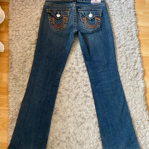 lowwaist bootcut true religion jeans - Snygga blå jeans från True Religion med broderade detaljer på bakfickorna och kontrastsömmar. Dom är i jätte fint skick🩷