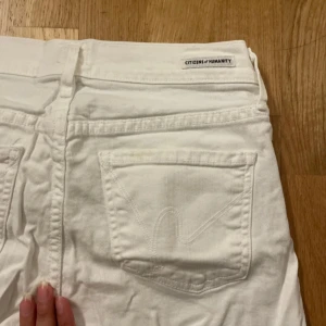 Snygga låg midja jeans från Citizens of Humanity - Snygga vita jeans från Citizens of Humanity med klassisk femficksdesign. De har en knappgylf och är i en stilren vit färg. Perfekta för en fräsch och stilren look.