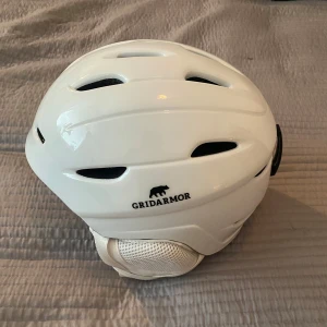 Vit skidhjälm från Gridarmor - Säljer en vit hjälm från Gridarmor, modell Kvittfjell Alpine Helmet. Hjälmen har flera ventilationsöppningar för bra luftflöde och en stilren design. Perfekt för alpina aktiviteter.
