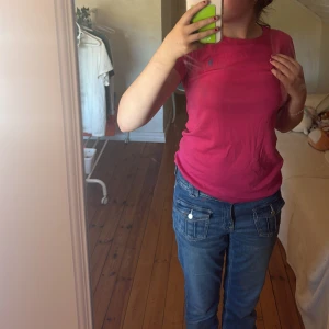 Rosa kortärmad topp från Ralph Lauren - Säljer en snygg rosa topp från Ralph Lauren med korta ärmar och en liten blå logga på bröstet. Perfekt för en avslappnad stil. Passar bra till jeans eller kjol.