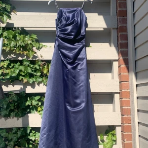 Mörkblå långklänning från Helena Crona - Elegant mörkblå strapless långklänning från Helena Crona med draperad detalj framtill. Perfekt för en stilfull kväll.                    Skriv gärna vid frågor eller för fler bilder :)