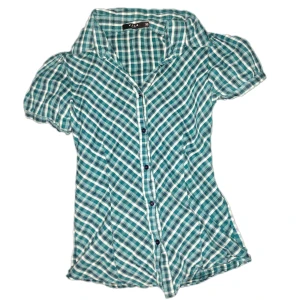 Fin rutig skjorta från Vila - Snygg blå och vit rutig skjorta från Vila. Skjortan har korta ärmar och knappar framtill. Perfekt för en avslappnad stil med en klassisk krage. Skriv om du vill ha bild hur den sitter på!