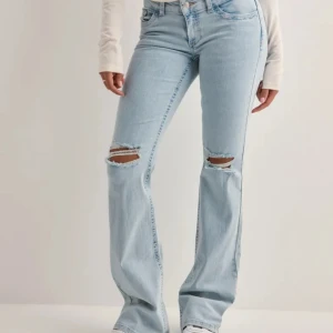 Lågmidjade jeans - Blåa låga jeans från Nelly med hål i, storlek 36