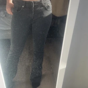 Svarta jeansbyxor - Snygga svarta jeansbyxor med en klassisk design. De har en normal passform och är perfekta för en stilren look. Byxorna har en dragkedja och knappar framtill.