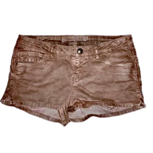 Lågmidjade shorts - Snygga bruna shorts med knapp och dragkedja framtill. De har en klassisk femficksdesign och är perfekta för varma dagar. Passar till många olika stilar och tillfällen.