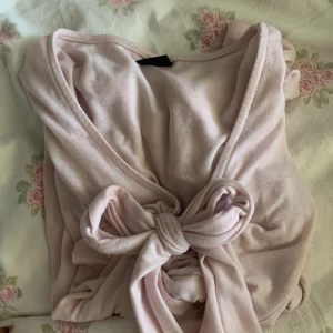 Rosa topp från Gina Tricot - Säljer en söt rosa topp från Gina Tricot med knytning framtill. Perfekt för en avslappnad och stilren look. Kom priv för mer bilder