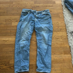 Blå jeans från Jack & Jones - Säljer ett par klassiska blå jeans från Jack & Jones. De har en normal passform och är tillverkade i bomull. Perfekta för en avslappnad stil.