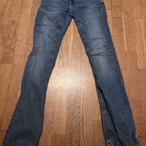 Blå jeans med bootcut - Snygga blå jeans med bootcut och klassisk femficksdesign. De har en lätt tvättad look och dekorativa sömmar på bakfickorna. Perfekta för en avslappnad stil. Storlek 152