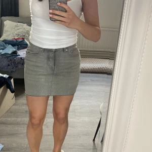 Grå jeanskjol - Snygg grå jeanskjol i kort modell med klassisk femficksdesign. 