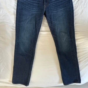 Levis 514 jeans i mörkblå denim - Säljer ett par klassiska Levis 514 jeans i mörkblå denim. De har en rak passform och är perfekta för en stilren look. Jeansen har de ikoniska bakfickorna och en läderpatch med Levis logga baktill.