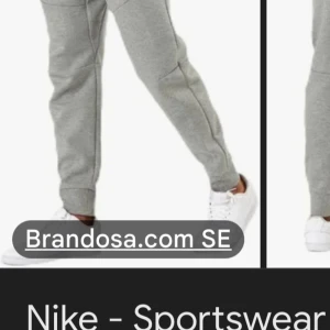 Grå mjukisbyxor från Nike - Säljer ett par grå mjukisbyxor från Nike med snörning i midjan och ribbade muddar vid bensluten. Perfekta för en avslappnad stil. Byxorna har en liten Nike-logga på sidan.