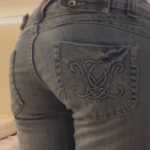 Blå jeans med broderad bakficka strl S - Snygga blå jeans från Big Star med broderade detaljer på bakfickorna. De har en låg midja och en bootcut-stil som ger en avslappnad look. Perfekta för en casual outfit. Snygga ljusblå bootcut jeans med broderade detaljer på bakfickorna. Storlek 8 vilket motsvarar S! Midjemått ca 35 cm tvärsöver o innebenslängden ca 74 cm