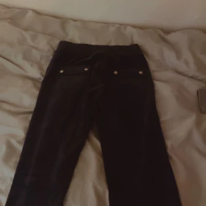 Juicy catoure byxor  - Snygga mörk blåa  med fickor och knappdetaljer baktill. Perfekta för en stilren look. Passar bra till både vardag och mer uppklädda tillfällen.