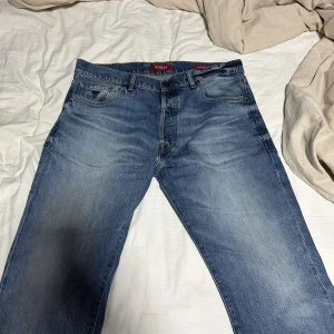 Blå jeansbyxor från Guess - Säljer ett par klassiska blå jeansbyxor från Guess. De har en normal passform med fem fickor och en dragkedja. Perfekta för en avslappnad stil.