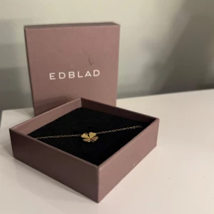 Guld halsband från Edblad - Elegant guldhalsband från Edblad med en charmig fyrklöverberlock. Perfekt som en stilren accessoar för att ge lite extra glans till din outfit. 45 cm🥰💋 Nästintill nytt då jag använder silversmycken🩷
