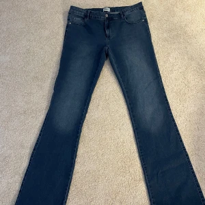 Mörkblå jeans från ONLY - Snygga mörkblå jeans från ONLY med en klassisk femficksdesign. De har en knapp och dragkedja framtill och är i modellen 'Sweet Flared' vilket ger en trendig look. Dom är i mycket bra skick och är aldrig använda. 