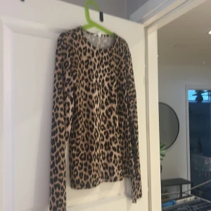 Leopardmönstrad långärmad topp - Säljer en snygg leopardmönstrad långärmad topp. Perfekt för att ge din outfit en trendig touch. Toppen har en normal passform och är tillverkad i ett mjukt material. Prislappen är kvar för den är aldrig använd!