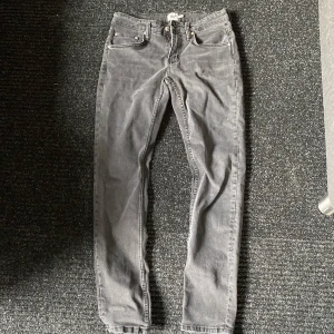 Gråa snygga jeans - Säljer ett par grå jeans med klassisk femficksdesign. Byxorna har normal passform och är tillverkade i jeanstyg. Perfekta för dig som gillar en stilren och enkel look.