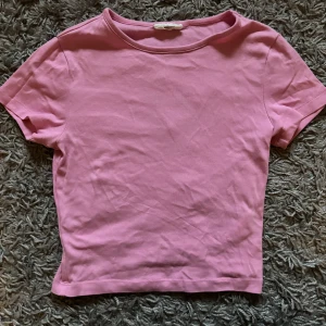 Rosa t-shirt från Gina Tricot - Säljer en enkel och stilren rosa t-shirt från Gina Tricot. T-shirten har rund halsringning och korta ärmar. Perfekt att matcha med jeans eller kjol för en avslappnad look. Använd fåtal gånger💕