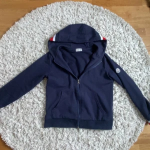 Mörkblå hoodie från Moncler - Snygg mörkblå hoodie från Moncler med dragkedja och huva. Använd runt 4 gånger. Skriv om ni är intresserade eller har några frågor!