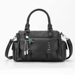 Svart axelväska med detaljer - Säljer en svart axelväska med både handtag och justerbar axelrem. Väskan har dekorativa spännen och nitar på framsidan samt flera fack. Perfekt storlek för vardagens prylar och enkel att matcha med olika outfits. Den lilla assessorer (de små diamanterna och stjärnan kommer med) ville bara visa att det går att ta bort❤️🥰