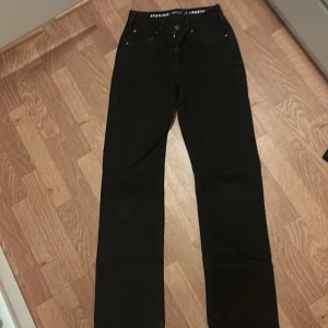 Svarta jeansbyxor low waist straight Bikbok - Svarta jeansbyxor med låg midja och raka ben. Klassisk femficksmodell med enkel design och diskreta sömmar. Midjemått W25 och längd 32. Perfekta för en stilren och avslappnad look.