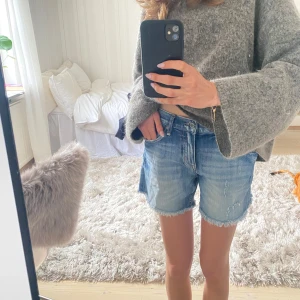 Blå jeansshorts medelhög/låg midja - Säljer ett par blå jeansshorts med snygga detaljer. Klassisk normal passform med fickor och knappgylf. Shortsen har medelhög/låg midja. Normala i storlek. Så snygga till sommaren!!