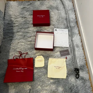 Ferragmo bälte - Säljer ett svart bälte från Salvatore Ferragamo med ett ikoniskt silverfärgat dubbel-Gancini-spänne. Bältet är i skinn och levereras med originalpåse, ask och kvitto. Perfekt accessoar för att lyfta din outfit.