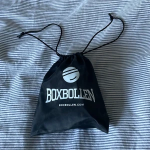 Svart förvaringspåse från Boxbollen - Säljer en svart förvaringspåse från Boxbollen med vitt tryck och dragsko. Perfekt för att förvara din boxboll och tillbehör. Enkel att ta med sig och smidig att använda🥊🥊