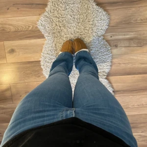 Blå bootcut jeans från NA-KD - Säljer ett par klassiska blå bootcut jeans från NA-KD. Jeansen har normal passform, hög midja och stängs med dragkedja och knapp. Perfekta för dig som gillar en tidlös stil med lite utsvängda ben.