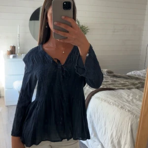 Mörkblå blus med knytning - Säljer en mörkblå blus med lång ärm och v-ringning med knytdetalj framtill🌊🫧☀️🤍