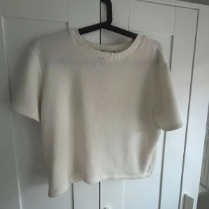 Vit stickad kortärmad tröja  - Säljer en fin  vit/ beige stickad tröja från Zara med korta ärmar och rund halsringning. Är i storlek L men är liten i storleken, passar som S 