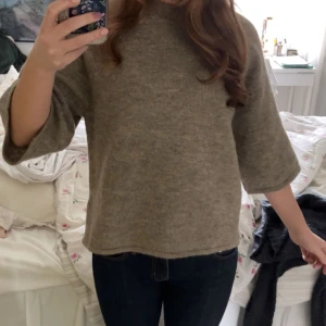 Beige stickad tröja med trekvartsärm - Mysig beige stickad tröja med trekvartsärmar och rak passform. Perfekt för lager-på-lager och enkel att matcha med jeans eller kjol. Klassisk och stilren design.