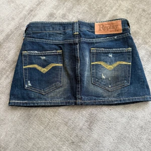 Mörkblå jeanskjol från Replay - Måste tyvärr sälja min skit coola replay kjol pågrund av att den är för liten. Kjolen har guldfärgade sömmar och en liten Replay-logga på fickan. Perfekt för dig som gillar en cool och avslappnad stil.