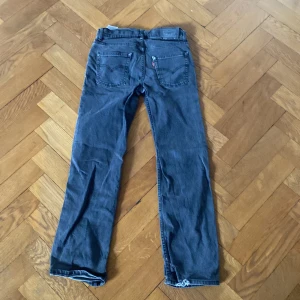 Mörkblå Levis 551Z jeans storlek 14 år - Säljer ett par mörkblå Levis 551Z jeans med klassisk femficksdesign och raka ben. Jeansen har normal passform och är tillverkade i slitstarkt denimtyg. Perfekta för dig som gillar en tidlös och avslappnad stil.