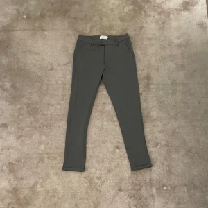 Grå kostymbyxor från Les Deux - Säljer ett par stilrena grå kostymbyxor från Les Deux. Byxorna har normal passform, bälteshällor och dragkedja. Perfekta för en clean och klassisk look. Storlek W28