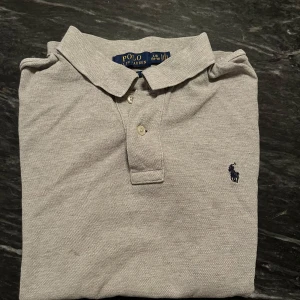 Grå Ralph Lauren piké  - Säljer en riktigt fet grå Ralph Lauren piké som är perfekt nu inför sommaren och varmare väder. Kontakta mig vid fler frågor!😁