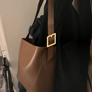 Brun väska Zara  - Brun Väska från Zara – Helt ny, aldrig använd. Inköpt för 699. Säljer för 450 kr  	•	Ingår en liten väska inuti 	•	Plats för dator – perfekt för både vardag och jobb  En stilren och praktisk väska som passar alla tillfällen! 🤎