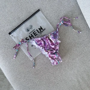 Mönstrad bikiniunderdel 💜 - En helt ny lila mönstrad bikiniunderdel från SHEIN i storlek S och har justerbara & knytbara band på sidorna. FÖRST TILL KVARN!💜(BUNDLERABATT VID KÖP AV FLER ARTIKLAR!)
