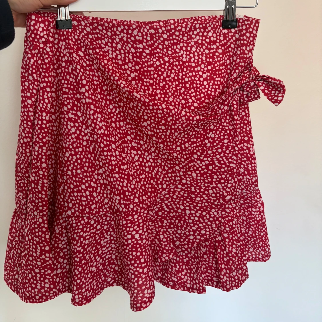 Röd kortkjol med vitprickigt mönster och volang