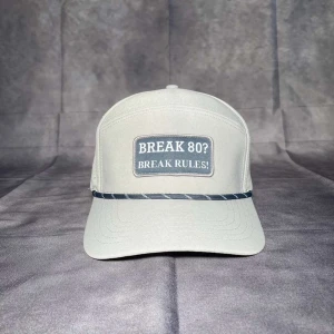 Beige keps med textbrodyr - Snygg beige keps med broderad patch framtill där det står 'BREAK 80? BREAK RULES!'. Kepsen har böjd skärm och en dekorativ snodd ovanför skärmen.