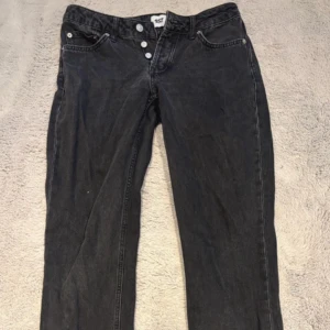 Svarta jeansbyxor med knappar - Säljer ett par svarta jeansbyxor med raka ben och knappgylf. Klassisk femficksmodell och normal passform. Perfekta till vardags för en avslappnad stil. Från lager157 i modellen ICON